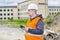 Construction Engineer with tablet PC near building