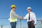 Construction engineer with worker shaking hands at construction