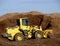 Construction Excavator and Scooper in Pile of Dirt