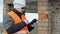 Construction foreman with tablet PC near unfinished building