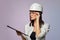 Construction girl in a white helmet, holding a folder. the concept of a business woman who understands construction, repair and