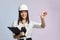 Construction girl in a white helmet, holding a folder. the concept of a business woman who understands construction, repair and