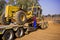 Construction grader on flatbed