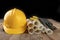 Construction helmet and roll of parchment with design. Construction engineer accessories on a wooden table