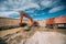 Construction industry - excavator working on highway construction site. Details of digging in water and dirt for viaduct construct