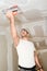 Construction industry worker with tools plastering walls and renovating house in construction site