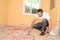 Construction industry worker with tools renovating house with floor tiles in construction site