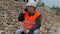 Construction inspector with phone at the pile of crushed stone