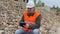 Construction inspector with tablet PC near crushed stone