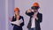 Construction male and female engineers in helmets with VR goggles managing building project in 3d