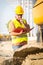 Construction manager controlling building site with plan