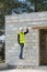 Construction manager in safety gear, on a ladder house under construction