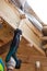 Construction mason worker sawing wood using hand-saw blade.