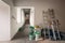 Construction materials, cans with paint , ladders and bags with cement, claircole and putty are stored an apartment i