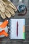 Construction measuring tape safety gloves notebook pen on wooden