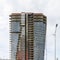 Construction of a modern high-rise made of glass and concrete, a tall building with glass panoramic windows, a