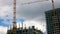 Construction of a modern high-rise residential building. A construction worker hooks a load and transports it with a construction