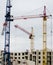 Construction of a multi-storey brick house using engineering technical structures, crane tower. Real work of builders.