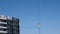 Construction of a multi-storey building. The hook of a construction crane against the sky.