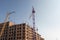 Construction of a multi-storey residential building. Glamorous purple tower crane.