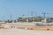 Construction of a new airport terminal building, view of cranes machinery and aircraft parked around. Transport hub reconstruction