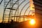 Construction of a new hangar in a semicircle of metal at sunset in the village.