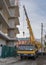 Construction of a new residential monolithic-frame house in the city using a truck crane in cloudy weather with clouds and wind