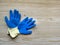 Construction rubberized gloves on a bright  wooden background. Blue protective rubber gloves for construction and operation with c