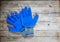 Construction rubberized gloves on a wooden background. Blue protective rubber gloves for construction and operation with caustic s