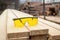Construction safety goggles on wood planks of sawmill. Woodworking industry