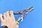 Construction scissors straight on metal in hand on a blue background