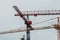 Construction site. Big industrial tower cranes with unfinished high raised buildings and blue sky in background. Scaffold. Modern