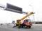 Construction site crane is lifting a led signboard for advertisement