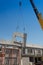 Construction site crane is lifting a precast concrete wall panel