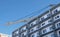 Construction site with cranes on sky background. The Builder works on the roof of a multi-storey building.