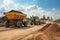 construction site with excavator loading dump truck with dirt