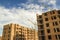 Construction site of a new apartment high building with tower cranes against blue sky. Residential area development. Real estate p