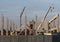 Construction site with pillars and the concrete block structure surrounded by a metallic barrier.