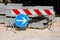 Construction site road signs directing traffic away from concrete curbs building material left on wooden pallets and gravel next