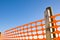 Construction site with safety orange grid against a blue sky