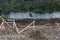 Construction site view of concrete retaining wall on hillside behind dug footings and rebar