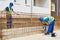 Construction site worker drills with a drill while his colleague checks the work done stock picture