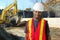 Construction site worker orange jacket and white security helmet