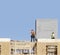 Construction site workers building roof on apartment complex