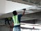 Construction site workers are doing ceiling soffit skim coat work at the construction site.