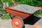 Construction Wheel Barrow with Pile of Gravel for House Foundation