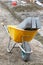Construction wheelbarrow with loaded concrete roadside blocks at a construction site. Vertical image