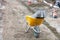 Construction wheelbarrow with loaded curb concrete blocks at a construction site