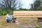 Construction of a wooden house in a rural area. A grown man is painting the house