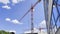 Construction work with a high-rise crane on a blue sky background. Construction of new houses